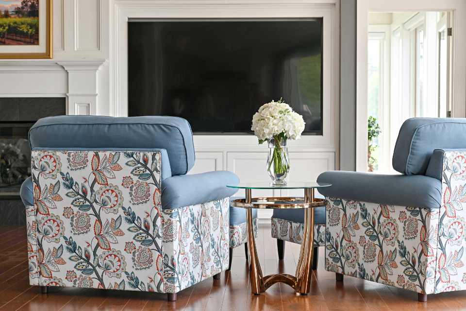 botanical print upholstered armchairs in designer tv room